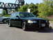 1999 Ford Crown Victoria - A black Ford Crown Victoria police car is parked outdoors with a bridge in the background.