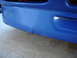 1998 Volkswagen Jetta - Blue car bumper corner shows a crack and scuff marks.