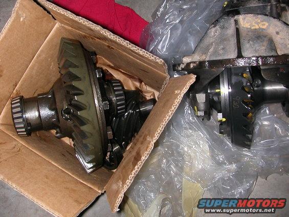 Differential gears in a cardboard box and plastic wrap. Text reads "SUPERMOTORS www.supermotors.net"