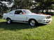 1978 Ford Mustang II - A white 1978 Ford Mustang II Cobra II with red racing stripes and side decals is parked on a grassy lawn.