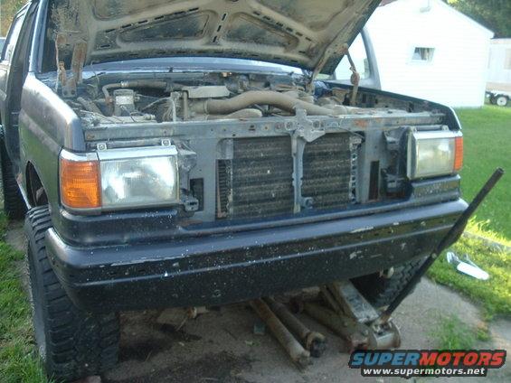 1989 Ford Bronco front with hood open, engine exposed, on a jack