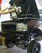 1994 Ford Bronco - Mechanics are installing a new engine into the front of a truck.