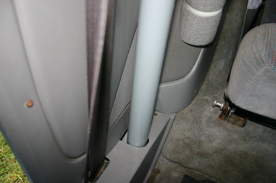 Interior view showing a gray roll bar, seatbelt, and part of a seat. The seat has a patterned fabric