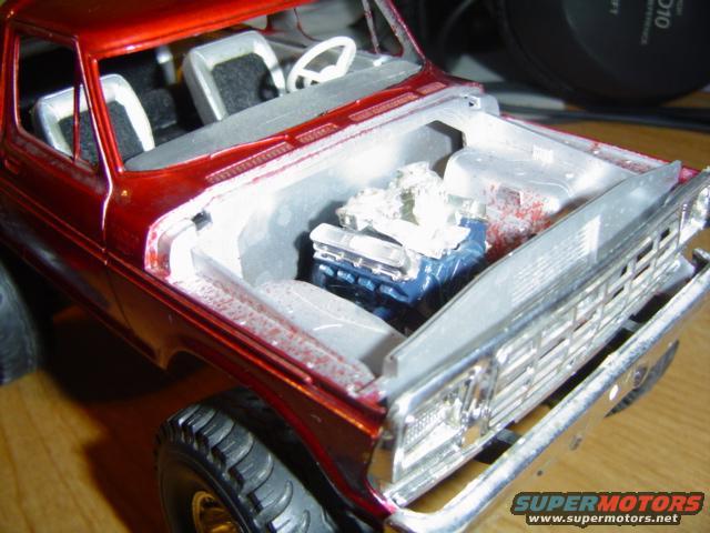 Model truck with engine exposed. Red paint, silver grille, and blue engine block visible