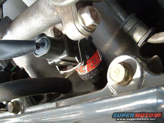 Close-up of an engine component with a red and white 'ERC' logo and visible bolts