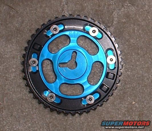 Adjustable camshaft gear with blue center and black outer ring, on a textured surface