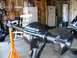 1995 Ford Bronco - A close-up view of a black rear axle assembly supported by an orange jack stand in a cluttered garage setting.