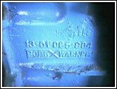 close-up of a transmission part with numbers 13-01-065-004 and FORDXWARNER stamped on it