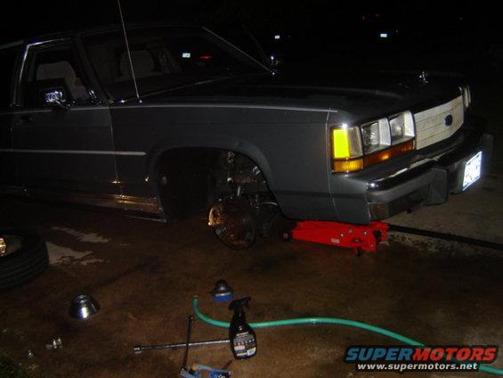 Dark gray 1988 Ford Crown Victoria LTD with front wheel removed, jacked up