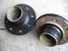 1995 Ford Bronco - Two wheel hubs are shown, one with a black finish and the other with rust on its flange.
