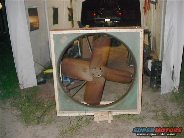 Large industrial fan with wooden frame and four brown blades
