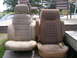 1984 Ford Bronco - Two car seats are displayed outdoors on a wooden deck, with a table and chairs in the background.