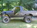 1986 Ford Bronco - This modified Ford Bronco features a yellow roll cage and off-road tires.