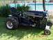 1979 Ford Bronco - This custom riding mower features large rear tires and an exposed engine, set against a backyard pool backdrop.