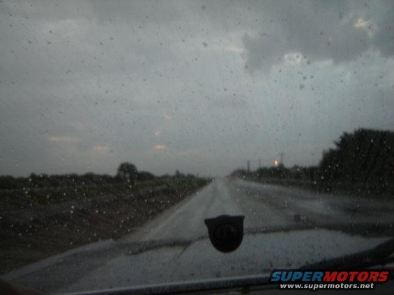 Interior view of a car driving on a wet road during a rainstorm