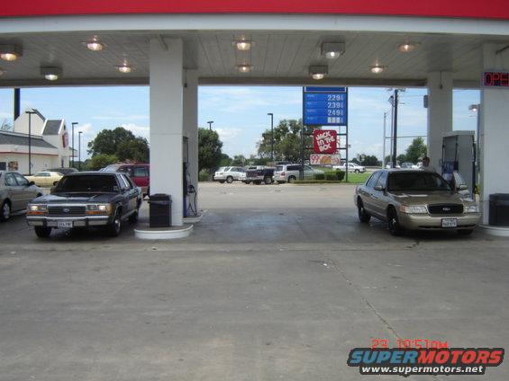 Gold Ford Crown Victoria at gas station, front view