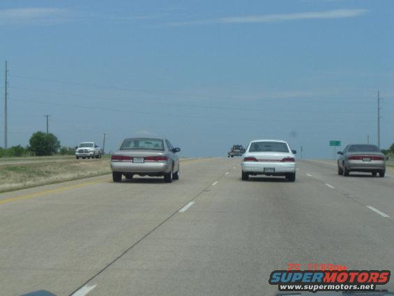 Car on highway, seen from behind. Another car is in the right lane