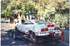 1978 Ford Mustang II - A white 1978 Ford Mustang II Cobra II is loaded onto a trailer, viewed from the rear with red racing stripes.