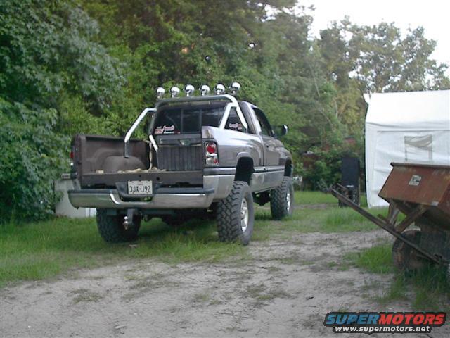Silver 1997 Dodge 1500 pickup truck, rear view, with custom roll bar and skull lights