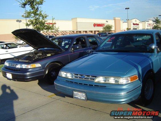 Blue 1992 Ford Crown Victoria front 3/4 view, hood open on dark blue Crown Victoria beside it