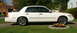 2000 Mercury Grand Marquis - White 2000 Mercury Grand Marquis sedan parked on a driveway with custom wheels.