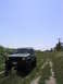 2000 Jeep Cherokee - A Jeep Cherokee XJ is parked on a dirt path surrounded by greenery under a clear blue sky.