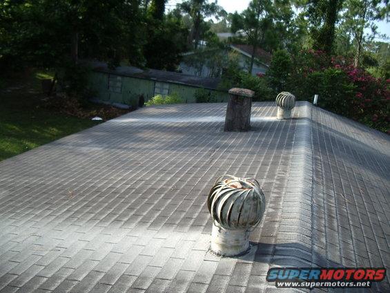 Roof with asphalt shingles, two turbine vents, and a brick chimney