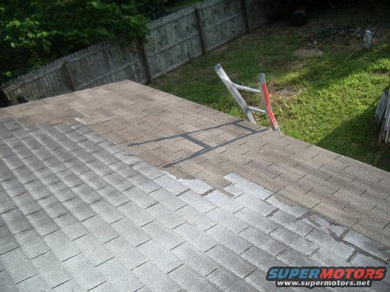 Roof with ladder and partially replaced shingles