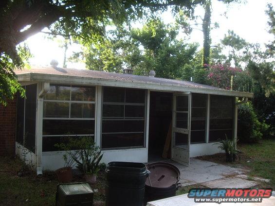 Screened-in porch with trash cans and storage bins