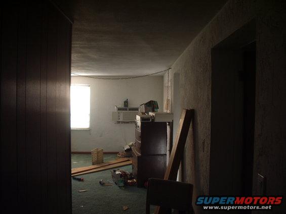 Interior room with a window, dresser, and construction materials on the floor