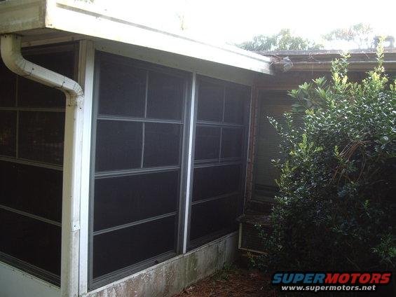 screened-in porch with gutters and bushes