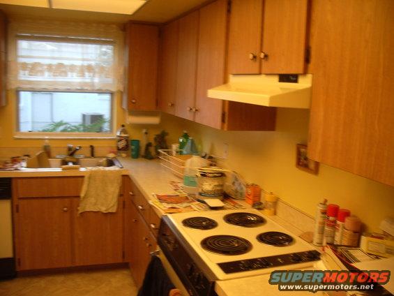 Kitchen with wood cabinets, sink, window, and electric stove