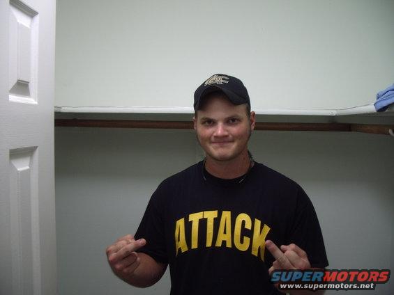 Man in black t-shirt with yellow text ATTACK, wearing a baseball cap