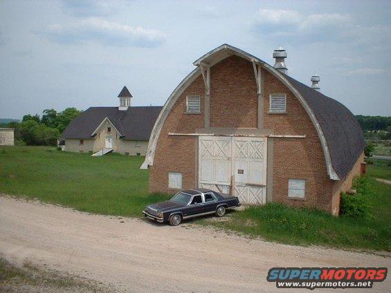 In front of one of the barns of the Traverse City State Hospital.  The barns were built just prior to the Depression.