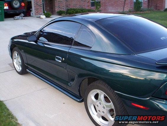 Dark green 1994 Ford Mustang coupe, rear quarter view. GT badge visible on rear quarter panel