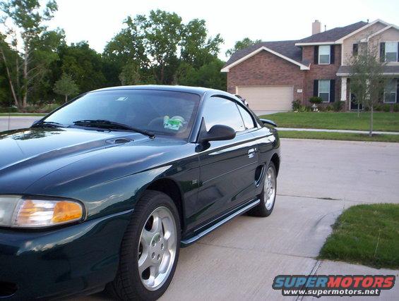 Dark green 1994 Ford Mustang parked in front of a house