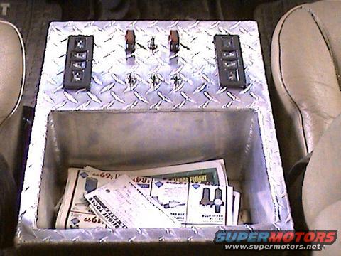 Custom diamond plate center console with four switches and papers inside. Visible text includes 'FREIGHT TOOLS'