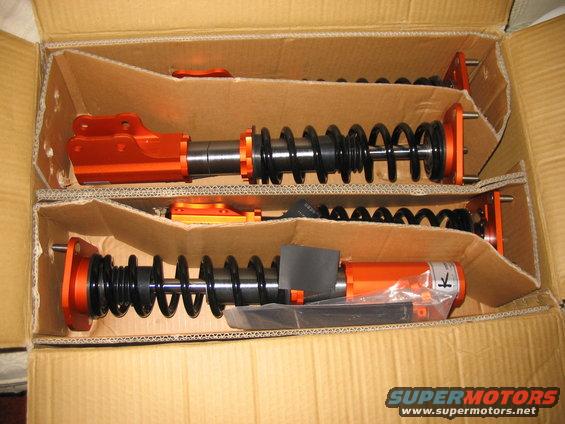 Orange and black coilover suspension parts in a box