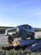 2000 Jeep Cherokee - A dark green Jeep Cherokee navigates an obstacle course of logs on a gravel road under a clear blue sky.