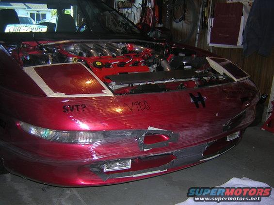 Red 1995 Ford Probe with hood open, front bumper covered in plastic wrap, SVT? and VTEC written on hood