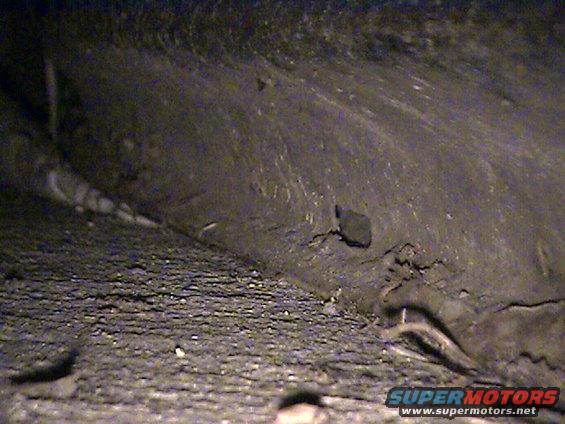 Underside of a vehicle, showing frame and road debris