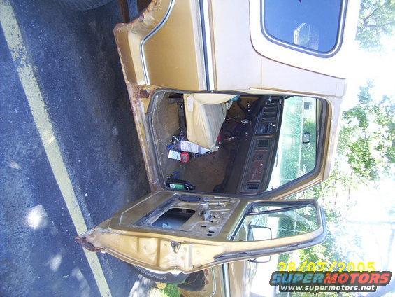 1979 Ford Bronco interior showing removed door, tan seats, and dashboard