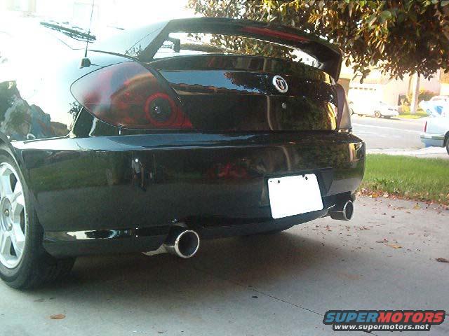 Rear view of a black 2003 Hyundai Tiburon with a spoiler and dual exhaust pipes