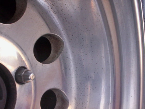 Aluminum wheel with multiple lug nut holes and visible pitting