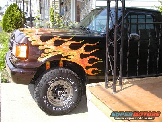 1991 Ford F-150 truck with custom flame graphics on the front fender and hood