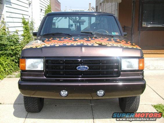 Brown 1991 Ford F-150 front view with orange and yellow flame decals on the hood