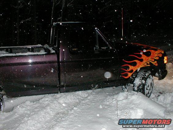 1991 Ford F-150 with flame decals stuck in snow