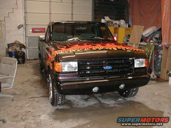 Dark pickup truck with flame decals, front view. 1991 Ford F-150