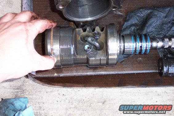 Here is the piston with worm gear installed.  Remove the two bolts, and then the two half-moon ball bearing guides.  Rotate the worm gear to drive out all of the balls.  Do not lose any of them or you'll be sorry.
