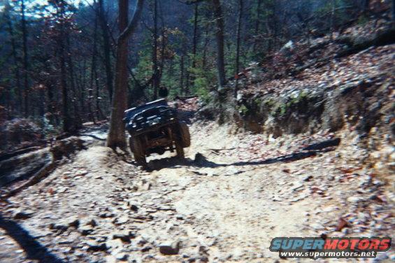 Off-road vehicle on a rocky, wooded trail